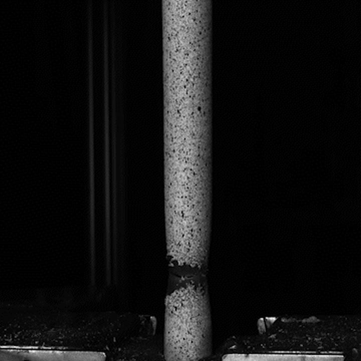 Steel pipe specimen necking under tensile load in a testing machine